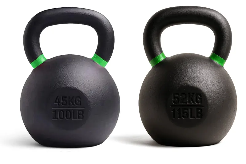 Two black kettlebells with green bands photographed against pure white