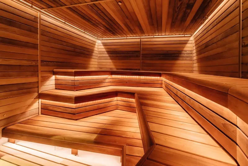Cedar-lined sauna interior with tiered benches under warm light